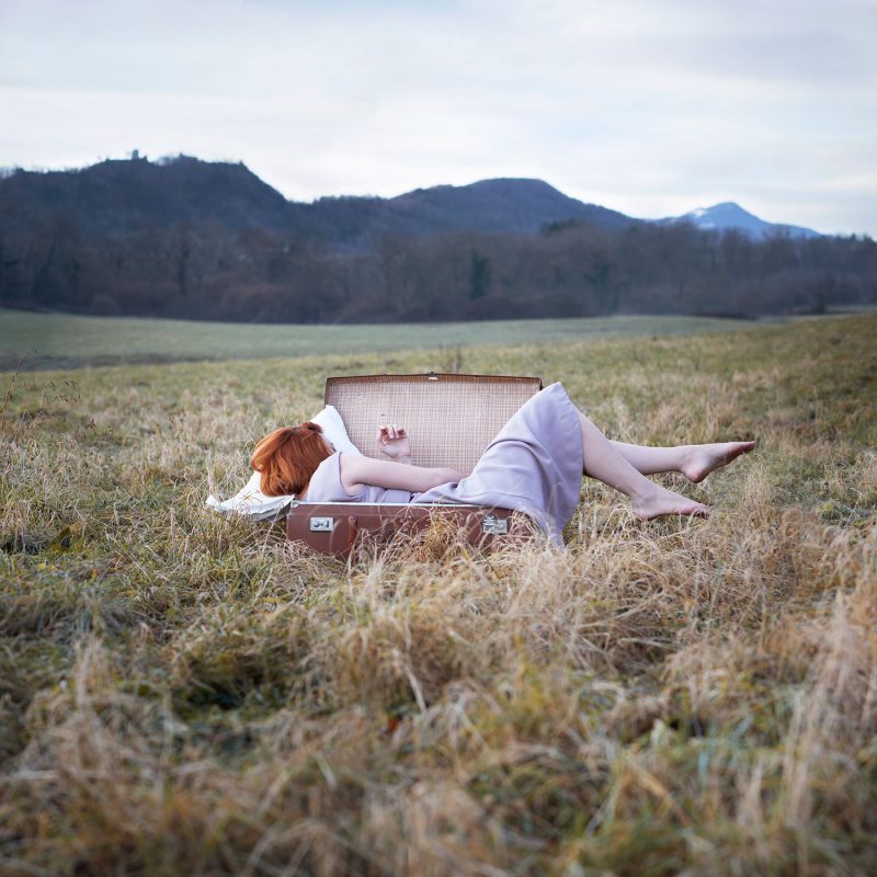 Delphine Millet Wake up - Staged photography delicate sensitive surrealist suitcase field alone dream travel nature - Art conceptual photographer in Berlin